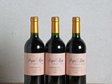 trois bouteilles de vin posées sur une table en bois