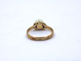 a close up of a gold ring with a pearl on it