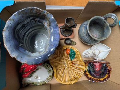 une boîte en carton remplie de nombreuses pièces de poterie de toutes sortes