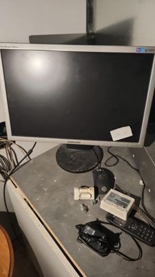 a desk with a computer monitor and other electronics on it