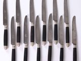 eight knives on a white surface with black handles