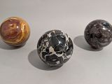 three marble balls sitting on a white surface