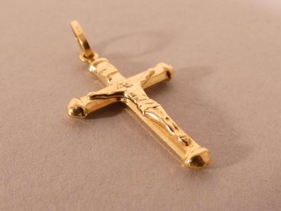 a gold cross that is laying on a table