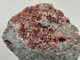 close up of a rock with red and white crystals on it