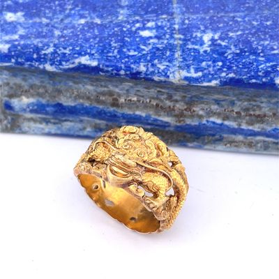 une image représentant une bague en or posée sur une pierre bleue