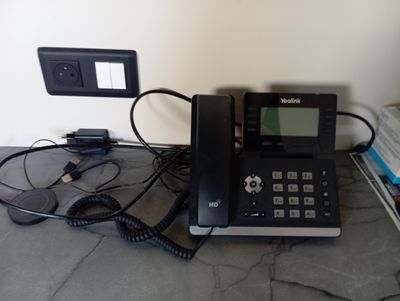 un téléphone posé sur une table près d'un mur