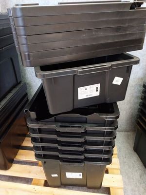 une pile de bacs en plastique posée sur une palette en bois