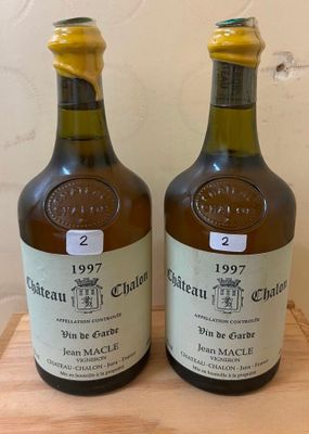 two bottles of wine sitting on top of a wooden cutting board