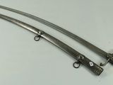a pair of two swords are sitting on a table