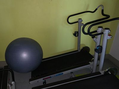 une salle de sport équipée d'un ballon, d'appareils de musculation et d'un ballon d'exercice