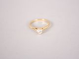 a gold ring with a single diamond in the middle