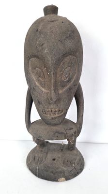 une statue représentant une tête d'extraterrestre posée sur un socle