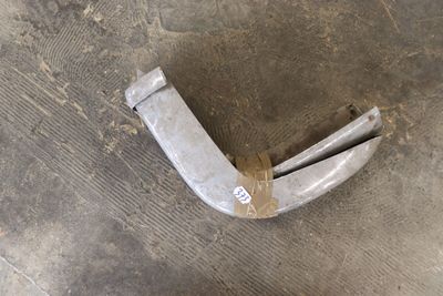 a piece of metal sitting on the ground with a piece of tape around it