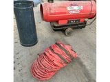 a red blower sitting next to a trash can and a trash can