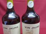 two bottles of wine are sitting on a red cloth