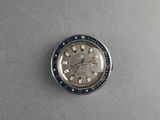 a close up of a watch on a table with a gray background