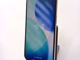 an image of a phone is sitting on a stand on a white surface