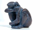 a figurine of a monkey that is sitting on a table