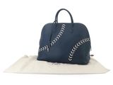 a blue leather handbag with white stitching on the side