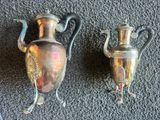 deux vases en argent posés l'un à côté de l'autre sur le sol