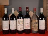 several bottles of wine are lined up on a red table