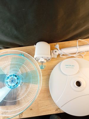 une table sur laquelle se trouvent un ventilateur et une télécommande