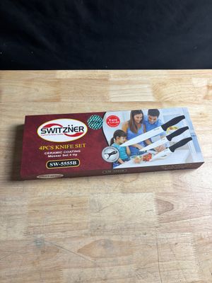 une boîte de couteaux posée sur une table à côté d'un aiguiseur de couteaux