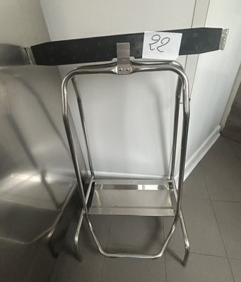 a metal step stool sitting next to a metal chair