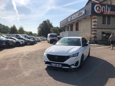 a white car parked in a parking lot in front of a building