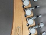 the heads of a guitar are lined up on a gray surface
