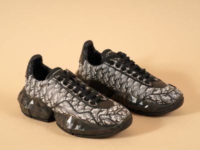 des baskets noires et blanches avec des lacets noirs, sur fond beige