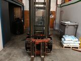 un chariot élévateur dans un entrepôt, avec des palettes au premier plan