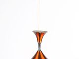an image of a copper colored pendant light hanging from a ceiling