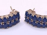 two pairs of blue stone earrings on a white surface
