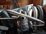 a pile of metal pipes and a blower in a room