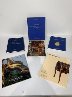 Quatre livres sont posés sur une table blanche, avec des couvertures bleues.