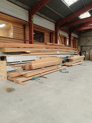de nombreuses pièces de bois empilées dans un entrepôt