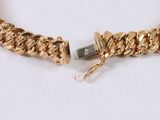 a close up of a gold bracelet on a white surface