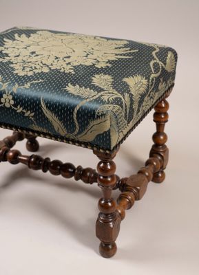 un petit repose-pieds orné d'un motif bleu et or