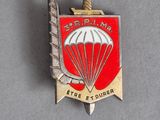 un gros plan d'un insigne sur lequel figure un parachute