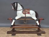 a wooden rocking horse with a saddle on it