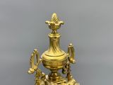 a gold colored vase with a bird on top of it