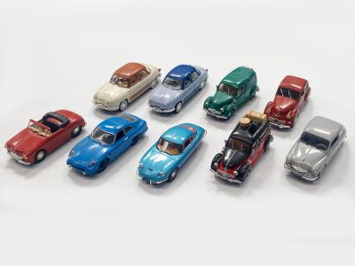 several toy cars are lined up in a row on a white surface