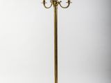 un lampadaire doré surmonté d'un abat-jour blanc