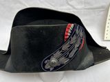 un chapeau noir orné d'un ruban rouge et bleu