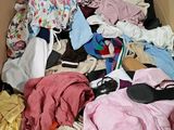 une boîte remplie de vêtements et de chaussures qui s'y trouvent