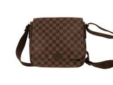 un sac à bandoulière à carreaux marron et noirs sur fond blanc