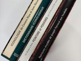 trois livres sont empilés sur une table