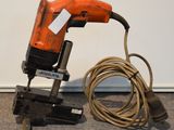 une agrafeuse filaire et une autre agrafeuse filaire posées par terre