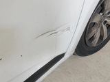 a white car that has been damaged and is parked on the side of the road